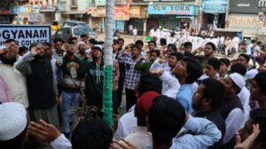 Flag hoisting ceremony at Gyanam Junior College on Independence Day with students performing cultural programs in the background.