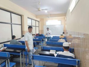 Flag hoisting ceremony at Gyanam Junior College on Independence Day with students performing cultural programs in the background.