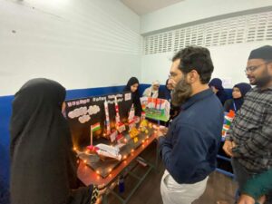 Flag hoisting ceremony at Gyanam Junior College on Independence Day with students performing cultural programs in the background.