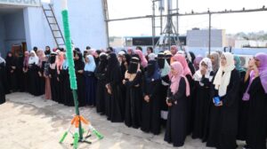 Flag hoisting ceremony at Gyanam Junior College on Independence Day with students performing cultural programs in the background.