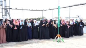 Flag hoisting ceremony at Gyanam Junior College on Independence Day with students performing cultural programs in the background.